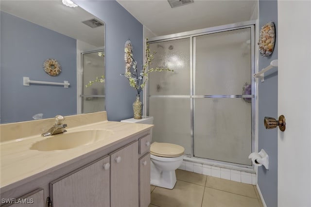 bathroom featuring vanity, a shower with shower door, toilet, and tile patterned floors