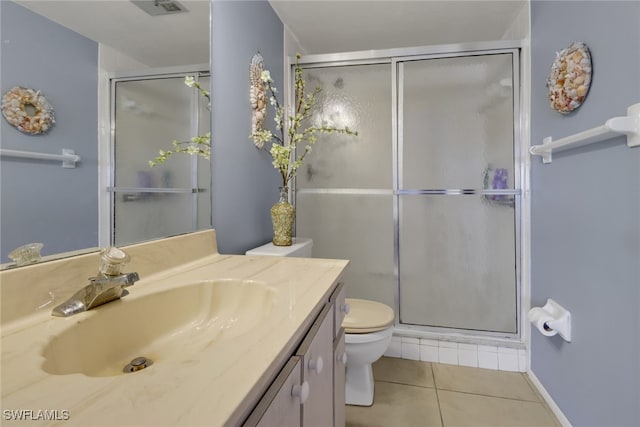 bathroom featuring tile patterned floors, a shower with door, vanity, and toilet