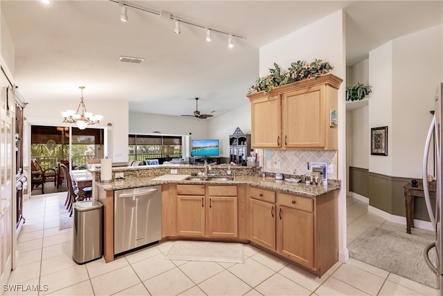 kitchen featuring light stone counters, light tile patterned flooring, ceiling fan with notable chandelier, stainless steel dishwasher, and kitchen peninsula