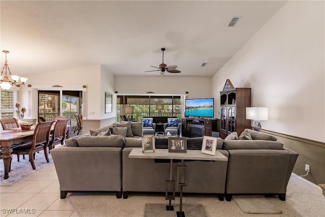 living room with light tile patterned flooring, lofted ceiling, and ceiling fan with notable chandelier