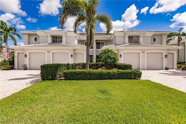 mediterranean / spanish house with a garage and a front lawn