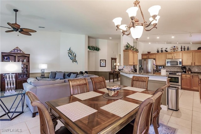 tiled dining space featuring ceiling fan with notable chandelier