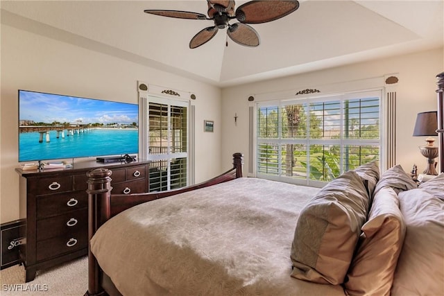 carpeted bedroom featuring a raised ceiling and ceiling fan