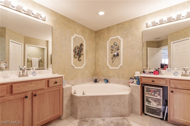 bathroom featuring tile patterned flooring, vanity, and a relaxing tiled tub