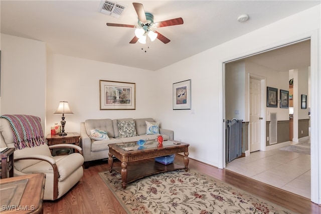 living room with light hardwood / wood-style flooring and ceiling fan