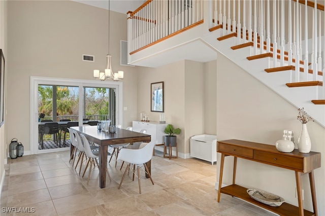 dining area featuring a high ceiling and a notable chandelier