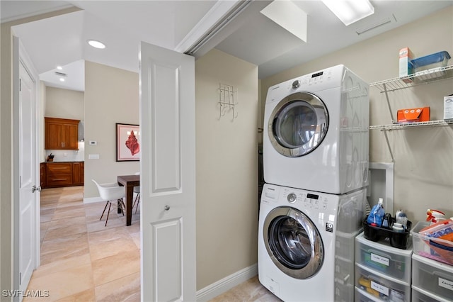 washroom featuring light tile patterned floors and stacked washer and clothes dryer