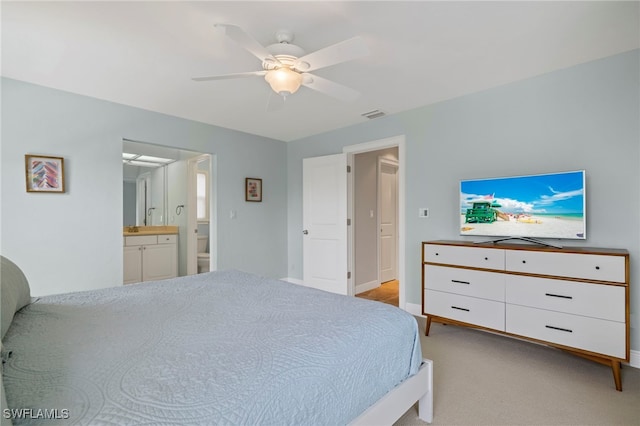 bedroom featuring light carpet, connected bathroom, and ceiling fan