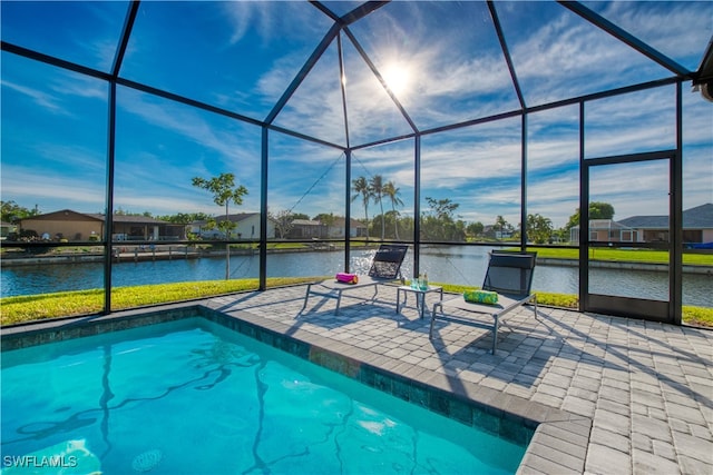 view of swimming pool featuring a water view, glass enclosure, and a patio area