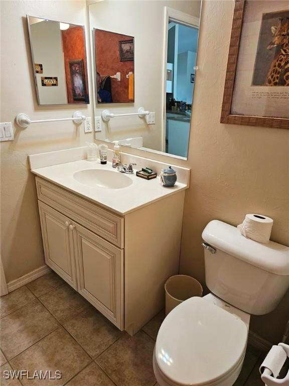 bathroom featuring tile patterned floors, vanity, and toilet