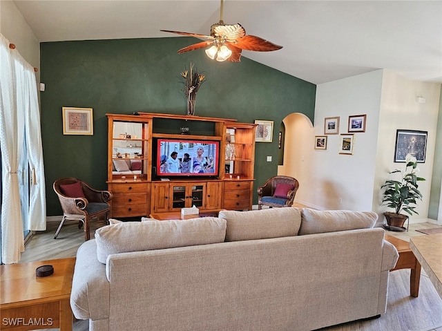 living room with ceiling fan, light hardwood / wood-style flooring, and vaulted ceiling