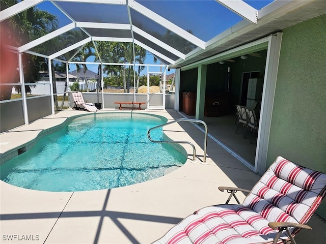 view of swimming pool featuring a lanai and a patio area