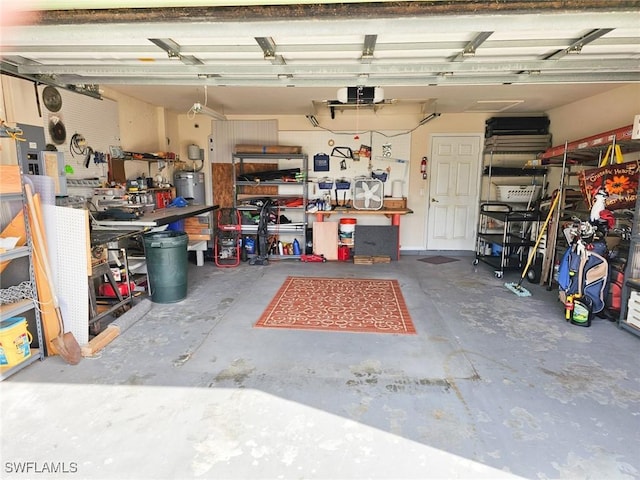 garage with a garage door opener, water heater, and a workshop area