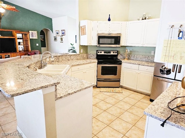 kitchen with light tile patterned flooring, appliances with stainless steel finishes, white cabinets, and sink