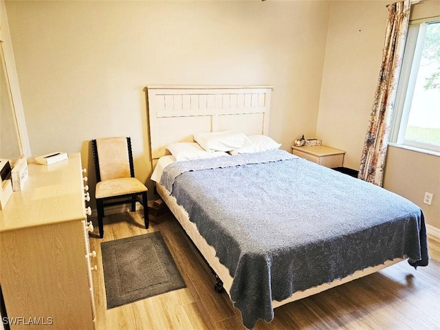 bedroom featuring wood-type flooring and multiple windows