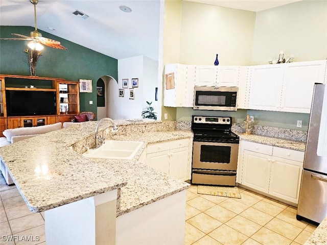 kitchen with light tile patterned floors, stainless steel appliances, light stone counters, and sink