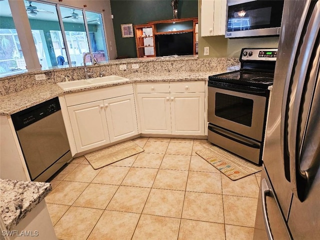 kitchen featuring white cabinets, appliances with stainless steel finishes, sink, and light tile patterned floors