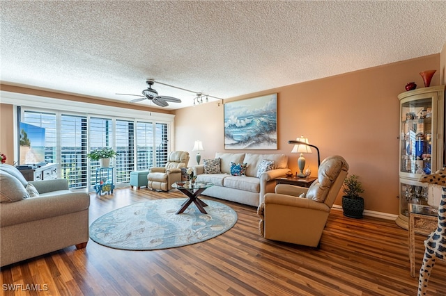 living room featuring ceiling fan, track lighting, hardwood / wood-style floors, and a textured ceiling