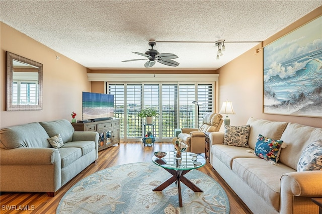 living room with hardwood / wood-style floors, ceiling fan, a healthy amount of sunlight, and a textured ceiling