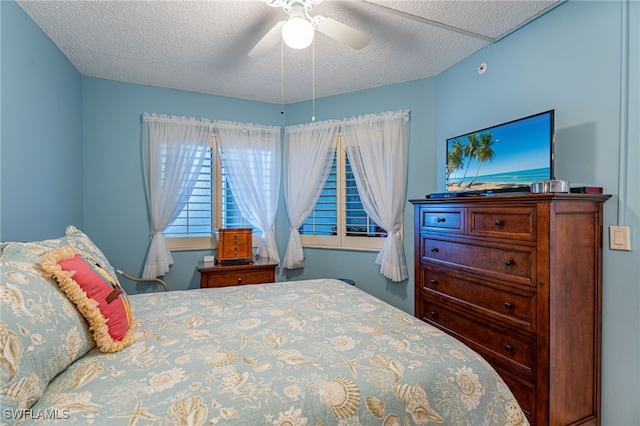 bedroom featuring ceiling fan and a textured ceiling