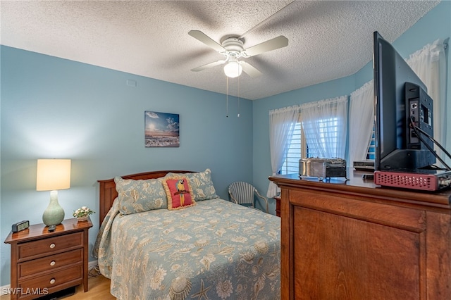 bedroom with light wood-type flooring, a textured ceiling, and ceiling fan