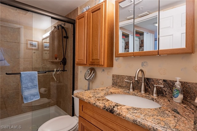 bathroom with walk in shower, vanity, and toilet