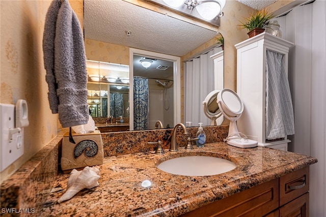 bathroom featuring a textured ceiling, vanity, and walk in shower