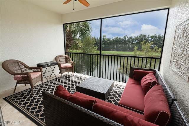 sunroom with a water view and ceiling fan