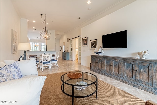 living room featuring ornamental molding, a chandelier, and a barn door