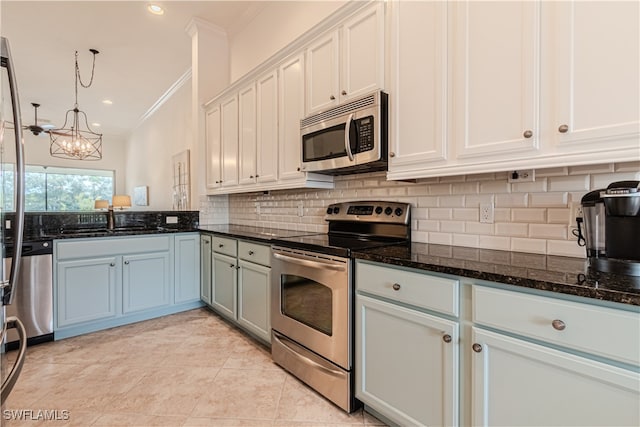 kitchen featuring white cabinets, stainless steel appliances, an inviting chandelier, ornamental molding, and sink