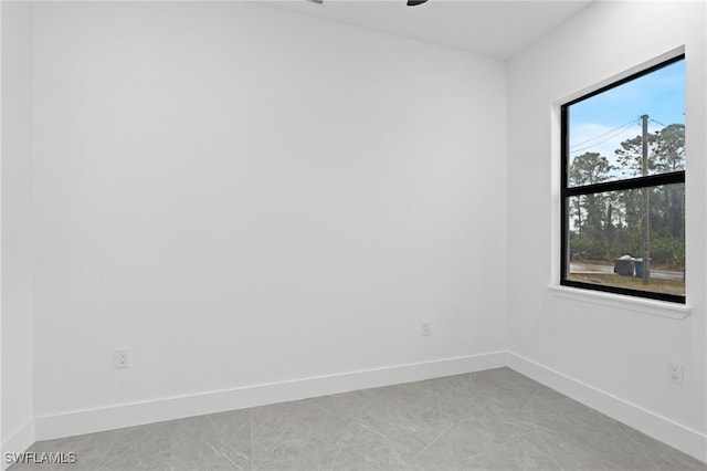 tiled spare room with a healthy amount of sunlight