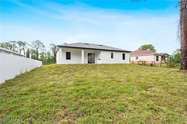 rear view of house featuring a lawn