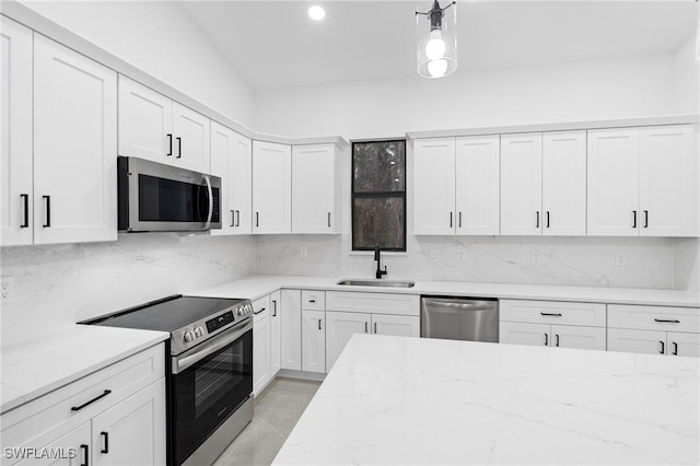 kitchen featuring decorative backsplash, appliances with stainless steel finishes, white cabinetry, and sink