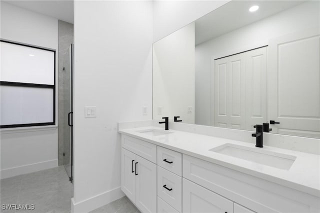 bathroom with tile patterned flooring, vanity, and walk in shower