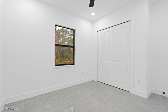 unfurnished bedroom featuring ceiling fan and a closet