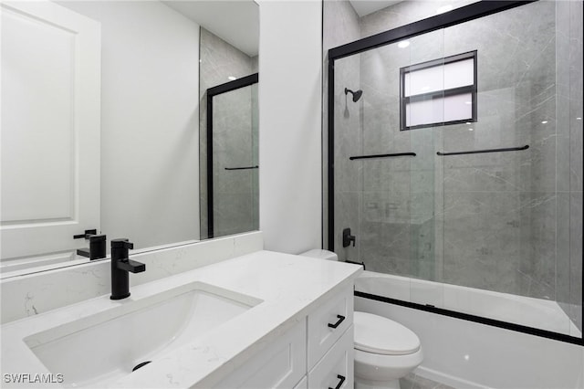 full bathroom with vanity, toilet, and bath / shower combo with glass door