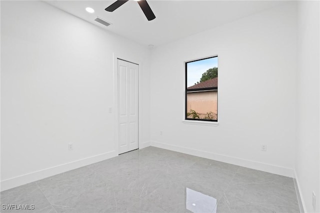 tiled empty room featuring ceiling fan