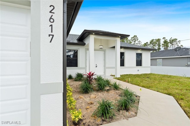 property entrance with a garage and a yard