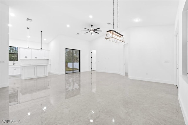 unfurnished living room featuring high vaulted ceiling and ceiling fan