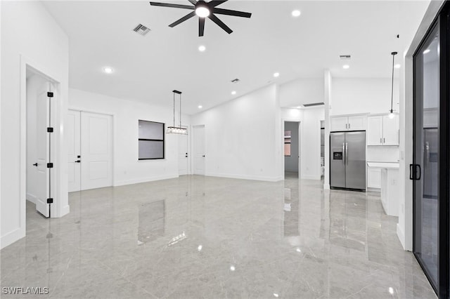 unfurnished living room featuring ceiling fan and lofted ceiling