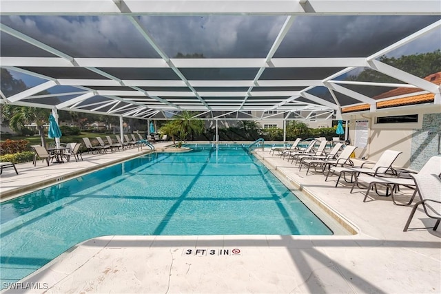 community pool featuring a patio and glass enclosure