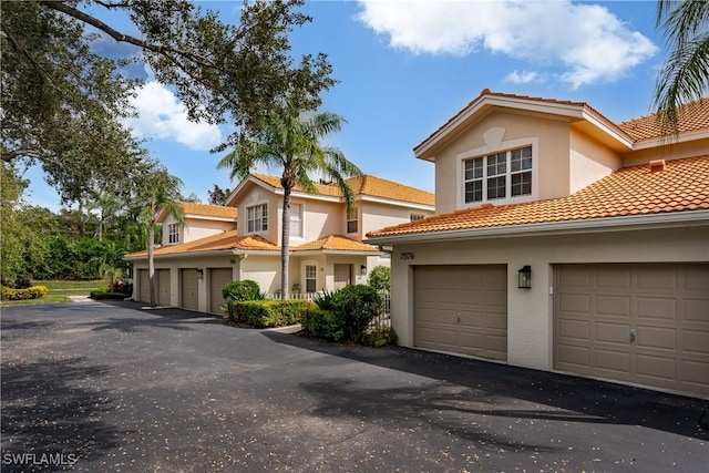 view of front of home featuring stucco siding, a garage, and a tile roof