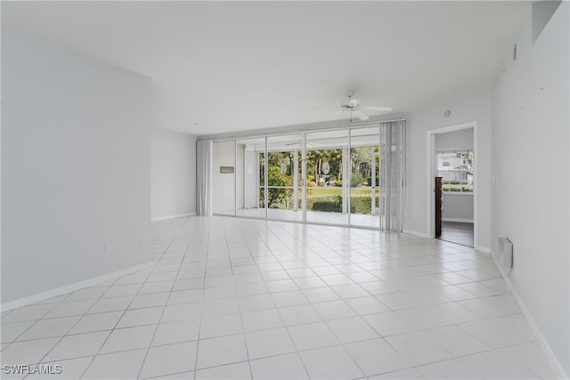 spare room featuring baseboards, a ceiling fan, and light tile patterned floors