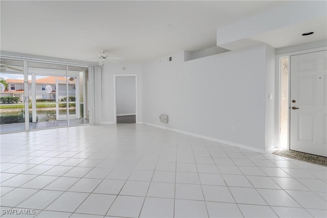 spare room with baseboards, visible vents, a ceiling fan, and light tile patterned floors