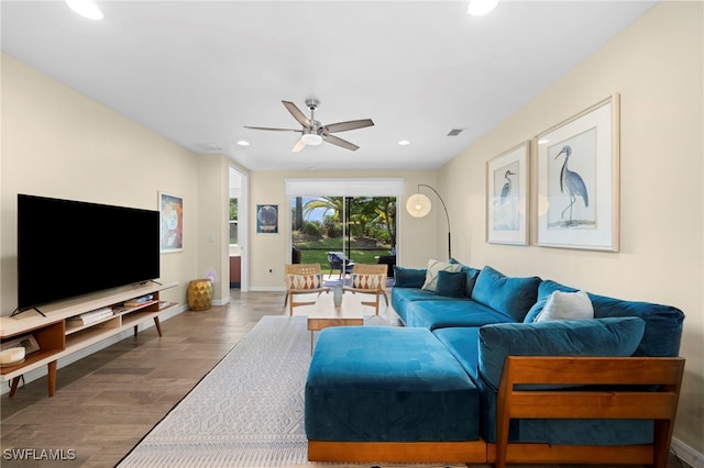 living room featuring wood-type flooring and ceiling fan