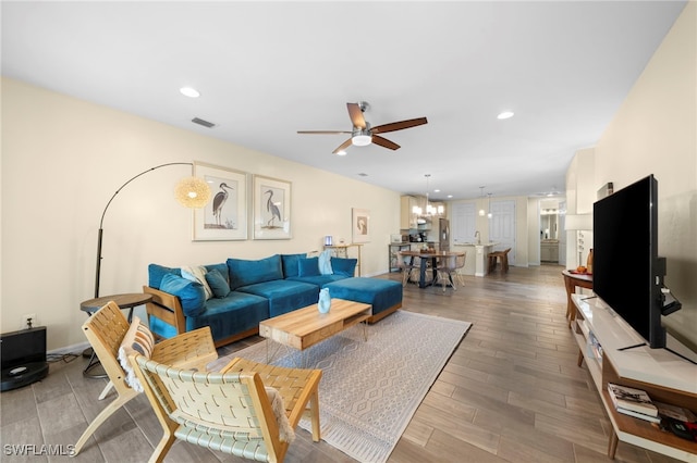 living room featuring ceiling fan with notable chandelier