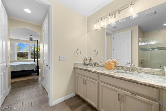 bathroom featuring ceiling fan, vanity, and walk in shower