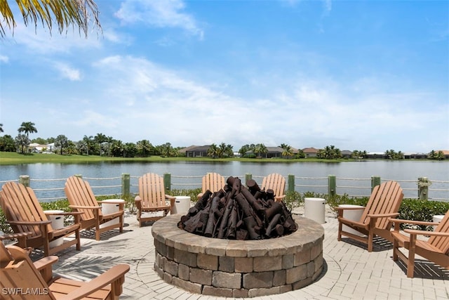 view of patio with a water view and an outdoor fire pit