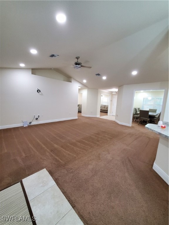 unfurnished living room with carpet, ceiling fan, and vaulted ceiling