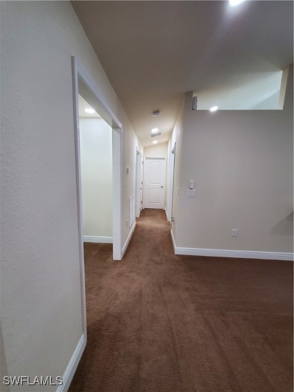 hall with dark colored carpet